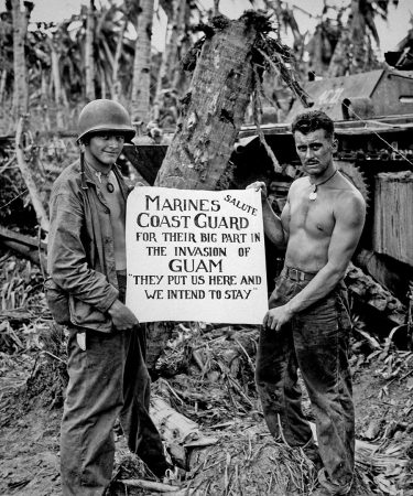 The U.S. Marines salute the U.S. Coast Guard after the battle on Guam, 1944